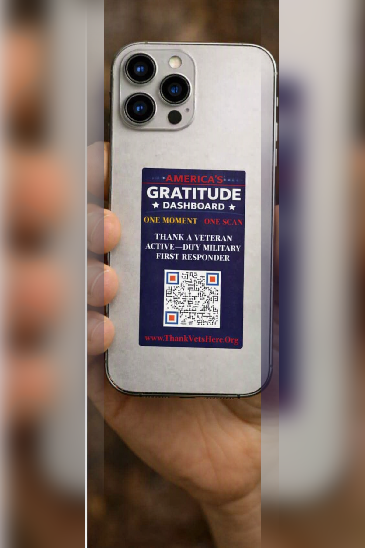 America's Gratitude Dashboard decal on the back of a phone held in a hand